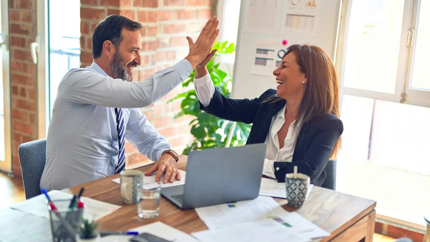 Two colleagues celebrating a deal