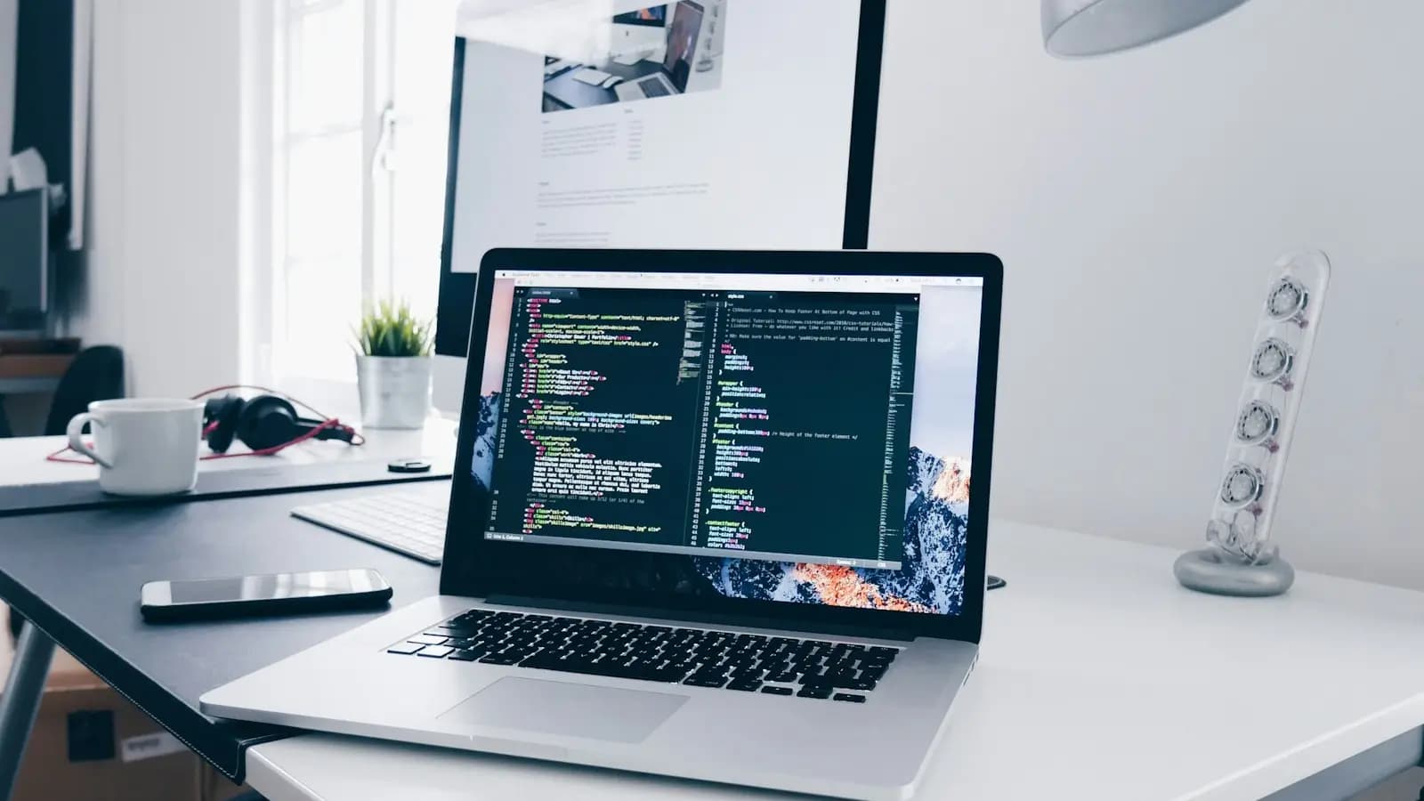Laptop with code on screen at a bright desk